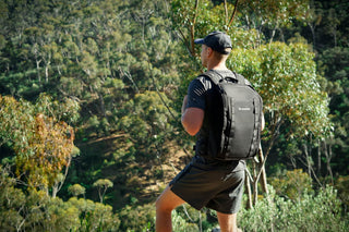 Man rucking through Australian bushland wearing a weighted Ruckaway backpack