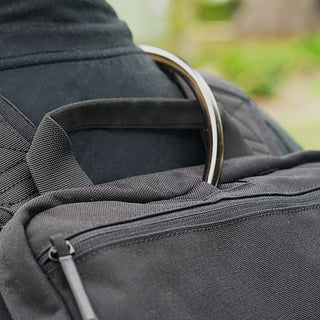 Close-up of a black backpack with a blurred natural background