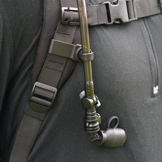 Green climbing harness attached to a gray backpack