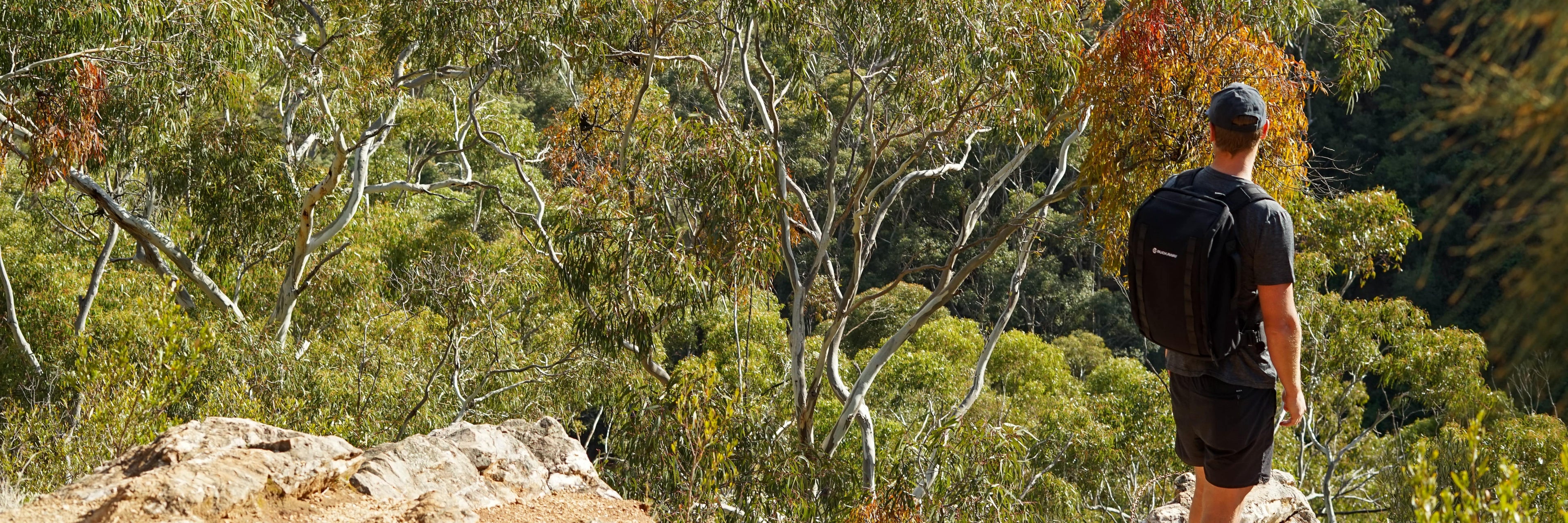 Man wearing Ruckaway rucking backpack standing on a hill