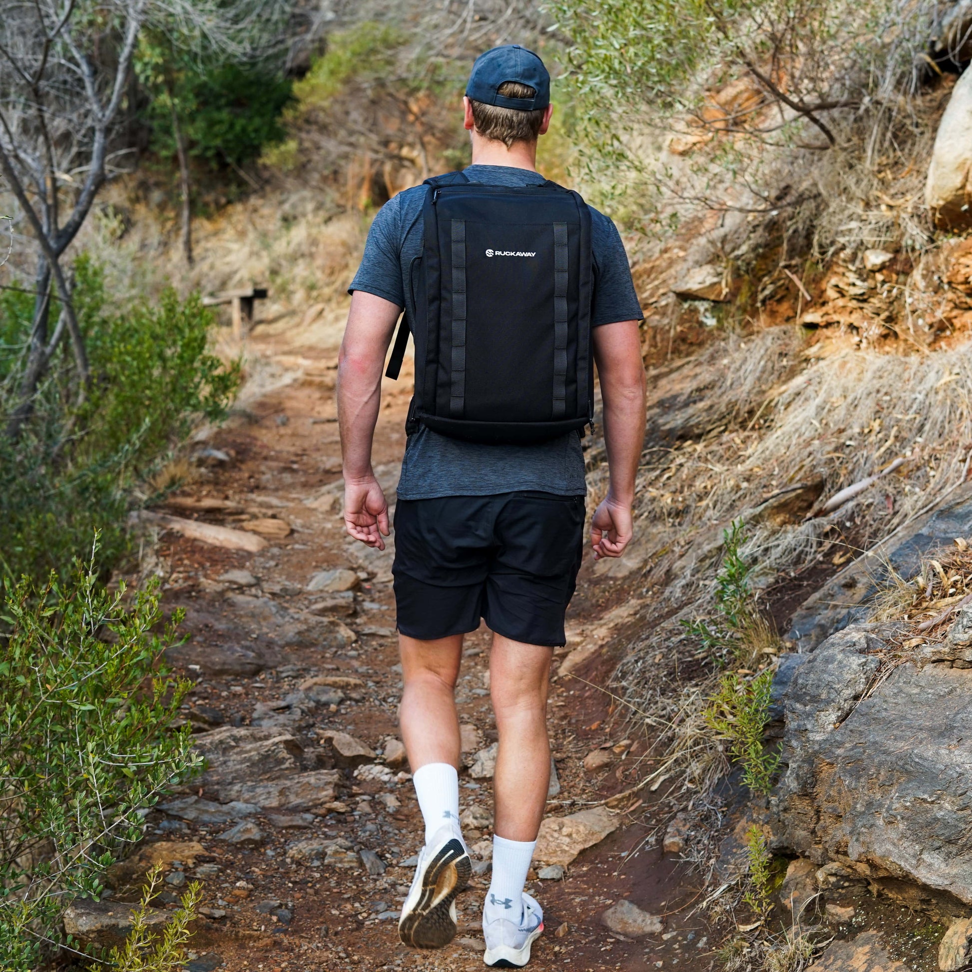 Man rucking uphill wearing Ruckaway weighted backpack