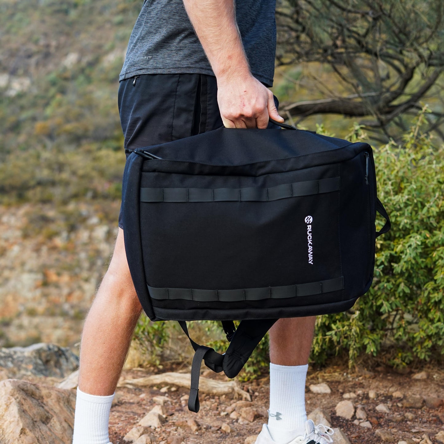 Man carrying Ruckaway rucking bag using side handle